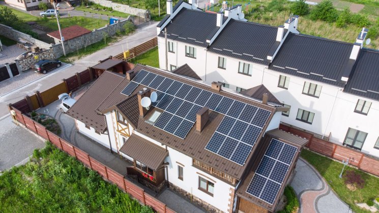 Drone image of multi-household buildings with solar panels on the roof