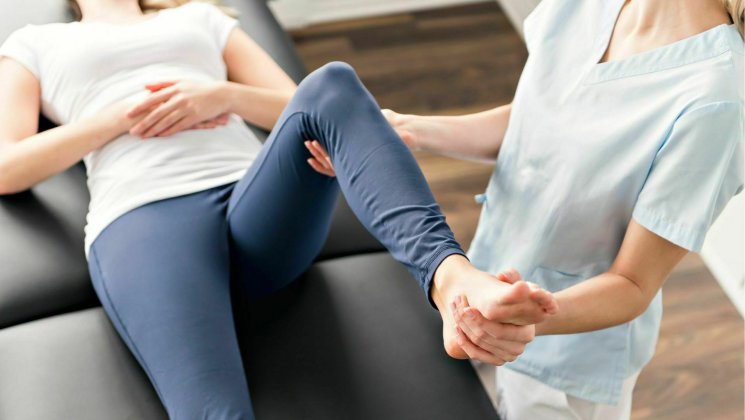 A physiotherapist testing a person's knee
