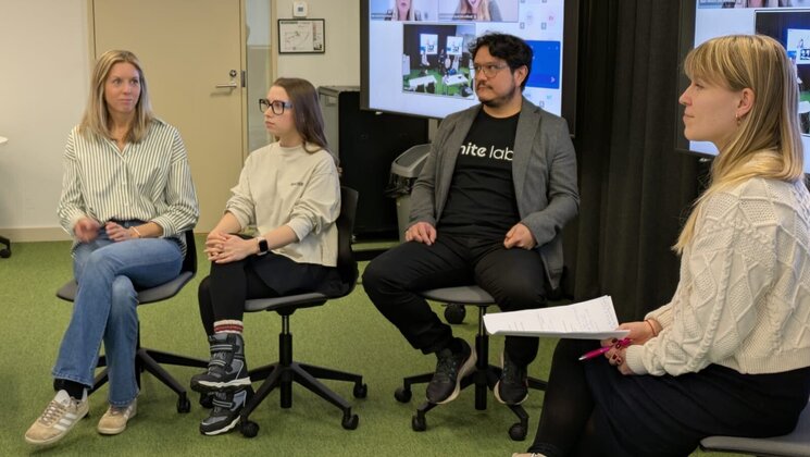 A photo of 4 people in conversation